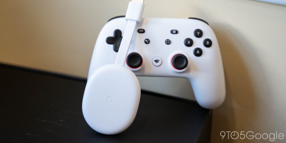Chromecast with Google TV leaning against a Stadia Controller