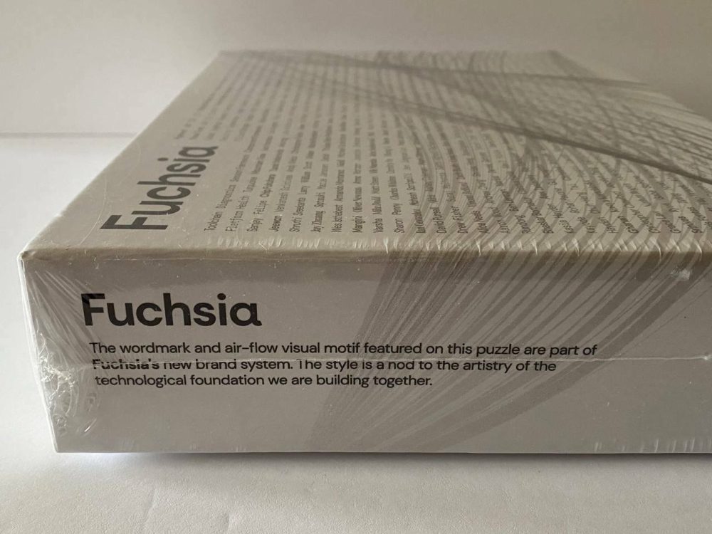 The side of a jigsaw puzzle box, with text explaining Fuchsia OS's "new brand system"