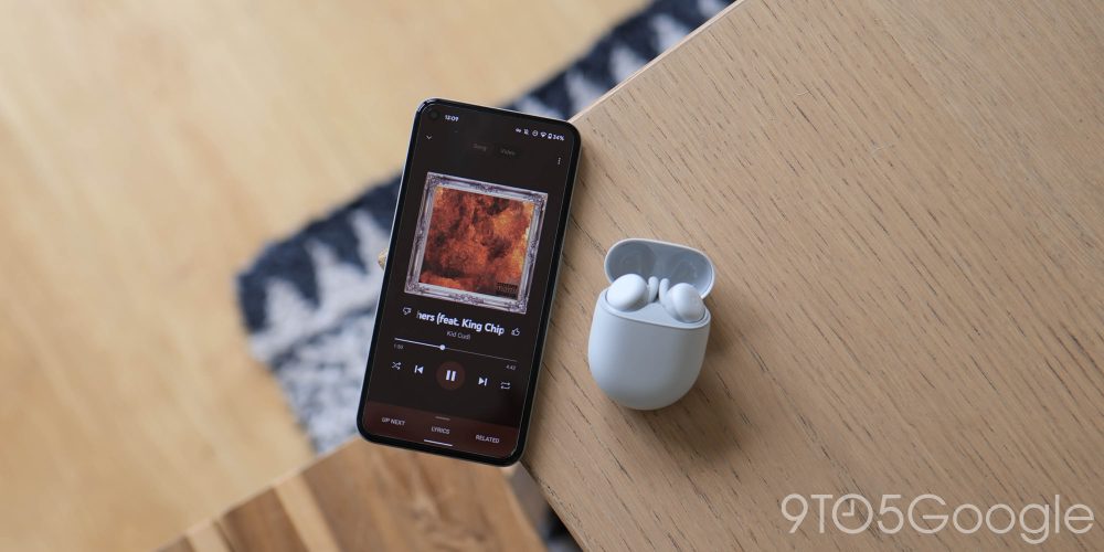 Google Pixel Buds A-series earbuds in white alongside the Pixel 5 playing Kid Cudi on YouTube Music for Android.