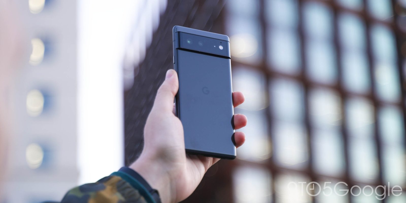 Google Pixel 6 in Stormy Black, held by an upraised hand